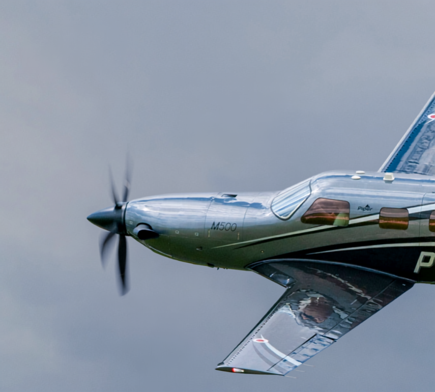 Piper M500 front half of plane in flight with gray skies