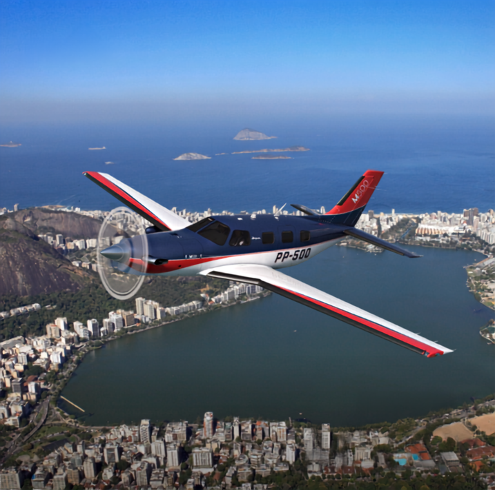 Piper M500 in flight over large city