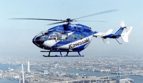 Kawasaki BK117 in flight over a city